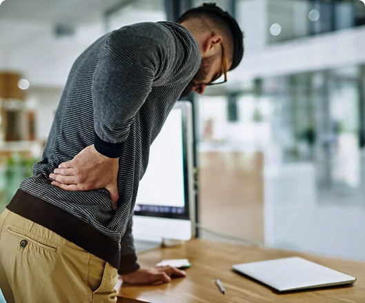 man holding his lower back in discomfort, representing chiropractic treatment for back pain and age-related discomfort at Champion Chiropractic in Coral Springs